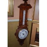 AN EARLY 20TH CENTURY OAK BAROMETER, OF BANJO FORM WITH CENTRAL ANEROID BAROMETER AND THERMOMETER TO