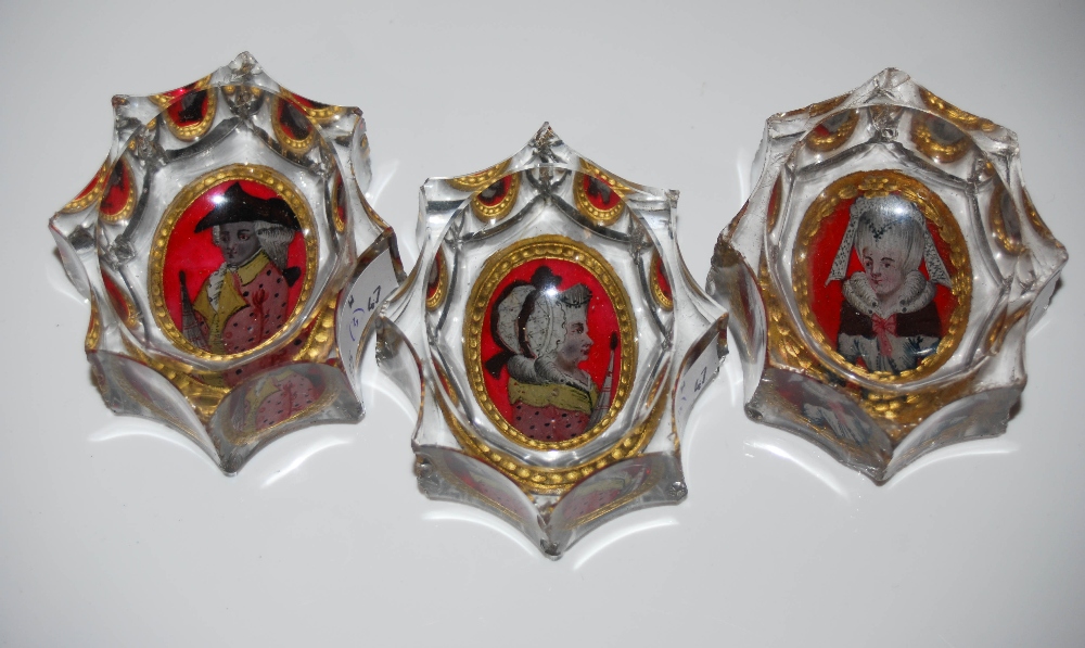 THREE FACET-CUT OVAL GLASS SALTS, EACH WITH REVERSE HAND-PAINTED PORTRAIT PANELS.