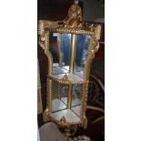 A LATE 19TH / EARLY 20TH CENTURY MIRRORED GILT WOOD WALL MOUNTED SHELF, THE THREE TIERED WITH