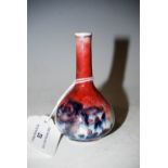 MINIATURE CHINESE BLUE, WHITE AND COPPER RED BOTTLE VASE DECORATED WITH TREES, PEONY AND