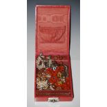 VINTAGE RED LEATHER JEWELLERY BOX CONTAINING ASSORTED COSTUME JEWELLERY TO INCLUDE WHITE METAL CAP