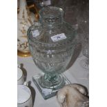 A 19TH CENTURY CUT GLASS URN-SHAPED JAR AND COVER.