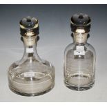 TWO SILVER-MOUNTED CLEAR GLASS DECANTERS AND STOPPERS.
