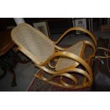 A BEECH WOOD ROCKING CHAIR WITH CANEWORK BACK AND SEAT