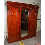 A VICTORIAN MAHOGANY WARDROBE, THE CENTRAL MIRROR DOOR FLANKED BY TWO PANELLED CUPBOARD DOORS