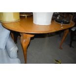 AN EARLY 20TH CENTURY OAK EXTENDING DINING TABLE, THE OVAL TOP ENCLOSING ONE ADDITIONAL LEAF ON FOUR