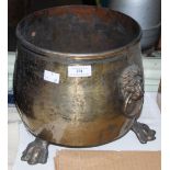 AN EARLY 20TH CENTURY BRASS PLANTER WITH LION MASK AND RING HANDLES RAISED ON THREE PAW FEET