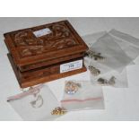 A RECTANGULAR CARVED WOOD BOX CONTAINING A SMALL COLLECTION OF ASSORTED NECKLACES AND PENDANTS TO