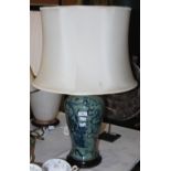 A DECORATIVE CELADON GROUND CERAMIC TABLE LAMP AND SHADE WITH BLUE PAINTED DETAILS