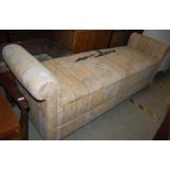 A LONG UPHOLSTERED RECTANGULAR OTTOMAN WITH HINGED SEAT OPENING TO AN OPEN RECESS BELOW FLANKED BY