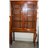 A STAINED PINE ASTRAGAL GLAZED TWO DOOR BOOKCASE TOP ON ASSOCIATED MAHOGANY CONSOLE TABLE