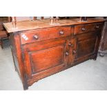 A LATE 19TH / EARLY 20TH CENTURY OAK DRESSER FITTED WITH TWO FRIEZE OVER TWO PANELLED CUPBOARD DOORS