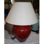 A DECORATIVE RED GLAZED CERAMIC TABLE LAMP AND SHADE
