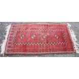 A SMALL PERSIAN CARPET, WITH RED FIELD WITH FOUR DARK BROWN AND IVORY MEDALLIONS IN SIMILAR BORDERS,