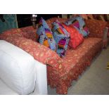 A 19TH CENTURY MAHOGANY SOFA WITH FLORAL UPHOLSTERED BACK, ARMS AND SEAT, RAISED ON SPLAYED MAHOGANY