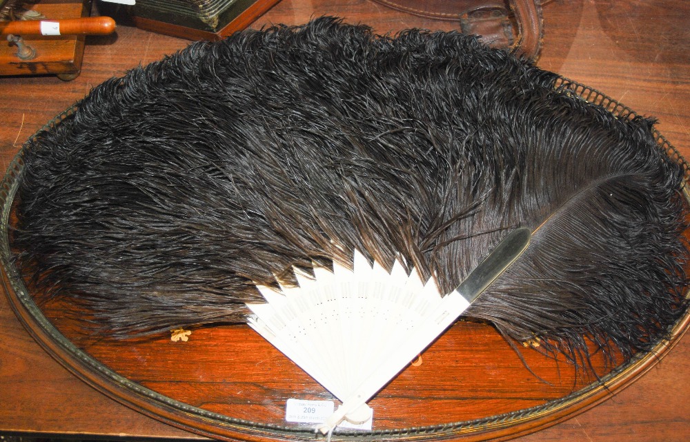 A LATE 19TH / EARLY 20TH CENTURY IVORY AND BLACK OSTRICH FEATHER FAN