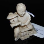 LATE 19TH CENTURY JAPANESE IVORY OKIMONO, KNEELING FIGURE HOLDING A LANTERN.