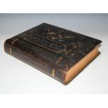 A VICTORIAN COMBINATION PHOTOGRAPH AND MUSICAL BOX ALBUM WITH EMBOSSED LEATHER COVERS AND GILT METAL