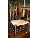 ARTS AND CRAFTS STAINED BEECH SIDE CHAIR WITH WAVY VERTICAL SPLATS AND WOVEN RUSH SEAT.