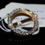 A YELLOW AND WHITE METAL DIAMOND AND CULTURED PEARL SET CIRCULAR BROOCH, SET WITH TWENTY-SIX VARIOUS