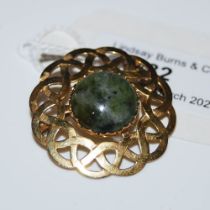 A 9CT GOLD AND GREEN AGATE CELTIC-FORM CIRCULAR BROOCH.