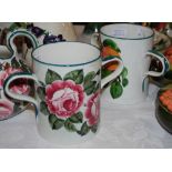 TWO WEMYSS WARE TWIN HANDLED CUPS, ONE DECORATED WITH PINK CABBAGE ROSES AND IMPRESSED 'WEMYSS WARE,