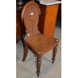 A 19TH CENTURY OAK HALL CHAIR WITH OVAL BACK, SOLID PLANK SEAT AND TAPERED OCTAGONAL SECTION