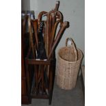 STAINED OAK STICK STAND CONTAINING A LARGE COLLECTION OF ASSORTED WALKING CANES, SHOOTING STICK,