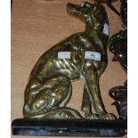 A VICTORIAN CAST IRON AND BRASS DOOR STOP, MODELLED AS A SEATED DOG, THE RECTANGULAR BASE WITH EGG