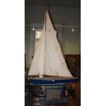 A LARGE EARLY 20TH CENTURY MODEL POND YACHT ON STAND, THE YACHT WITH BLUE AND WHITE PAINTED DETAILS,