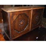 AN EARLY 20TH CENTURY STAINED OAK SIDE CABINET WITH TWO OCTAGONAL PANELLED DOORS