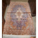 A 20TH CENTURY SILK MIDDLE EASTERN / TURKISH CARPET, THE RECTANGULAR ORANGE GROUND CENTRED WITH A