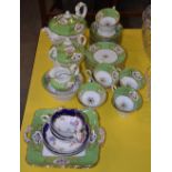 A 19TH CENTURY ENGLISH PORCELAIN APPLE GREEN GROUND PART TEASET, DECORATED WITH PANELS OF HAND