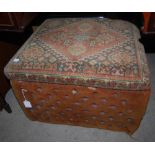 EARLY 20TH CENTURY CARPET UPHOLSTERED OTTOMAN WITH HINGED TOP, THE SIDES WITH BUTTON-DOWN
