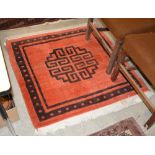 A 20TH CENTURY CHINESE / TIBETAN ORANGE GROUND RUG, THE RECTANGULAR FIELD CENTRED WITH LARGE SHOU