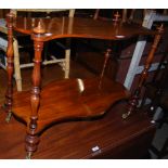 A VICTORIAN MAHOGANY TWO TIER SERPENTINE WHATNOT ON BRASS CUPS AND CASTORS