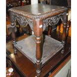 LATE 19TH/ EARLY 20TH CENTURY STAINED OAK SQUARE TWO-TIER OCCASIONAL TABLE WITH FLOWER AND FOLIATE