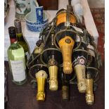 A METAL SIX BOTTLE WINE RACK CONTAINING ASSORTED BOTTLES OF CHAMPAGNE, VEUVE CLICQUOT, LAMBERT & CO,