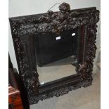 A COMPOSITE ROCOCO STYLE WALL MIRROR, THE FRAME SET WITH PUTTI, FLOWERS AND FOLIAGE