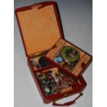 A RED LEATHER JEWELLERY BOX CONTAINING A COLLECTION OF ASSORTED COSTUME JEWELLERY, BRASS CASED