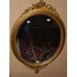 A 20TH CENTURY GILT OVAL MIRROR, WITH VINEOUS APPLIQUES TO THE TOP AND BOTTOM, 88CM HIGH