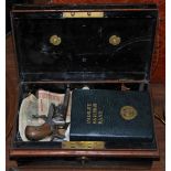 A JAPANNED METAL MONEY BOX CONTAINING COLLECTION OF ASSORTED COINAGE, BANK NOTES, PAISLEY SAVINGS