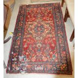 A 20TH CENTURY PERSIAN RUG, THE RECTANGULAR MADDER GROUND CENTRED WITH A BLUE GROUND FOLIATE