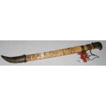 A 20TH CENTURY JAPANESE SHORT SWORD IN BONE WHITE METAL AND CABOCHON DECORATED SCABBARD, THE HILT