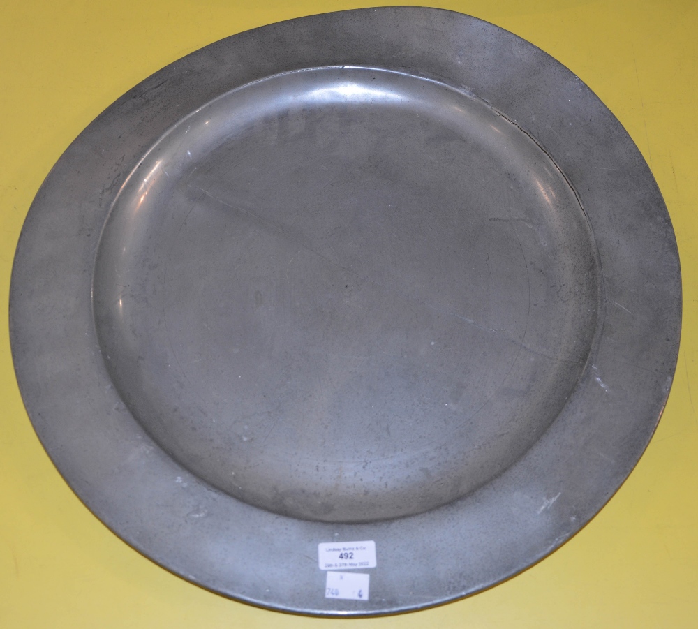 AN 18TH CENTURY LARGE PEWTER PLATE / CHARGER, THE BASE WITH IMPRESSED MARKS INCLUDING A TWICE STRUCK