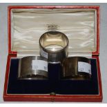 A CASED PAIR OF SHEFFIELD SILVER NAPKIN RINGS TOGETHER WITH ANOTHER BIRMINGHAM SILVER NAPKIN RING