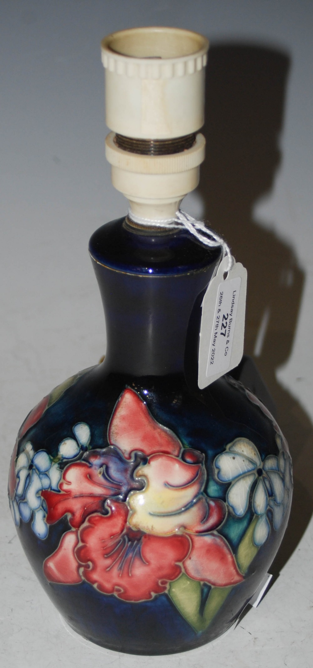 A MOORCROFT TABLE LAMP, THE BODY WITH FLORAL DESIGN ON A BLUE GROUND, IMPRESSED 'MOORCROFT' AND '