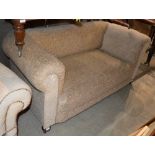 A 19TH CENTURY DROP END CHESTERFIELD TYPE SOFA WITH ALL-OVER FLORAL UPHOLSTERY ON BUN FEET AND