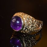 A 9CT YELLOW GOLD AND CABACHON AMETHYST DRESS RING, THE BAND WITH BRITISH HALLMARKS, APPROXIMATELY