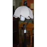 BLACK PAINTED CAST METAL STANDARD LAMP AND SHADE ON THREE SCROLL FEET